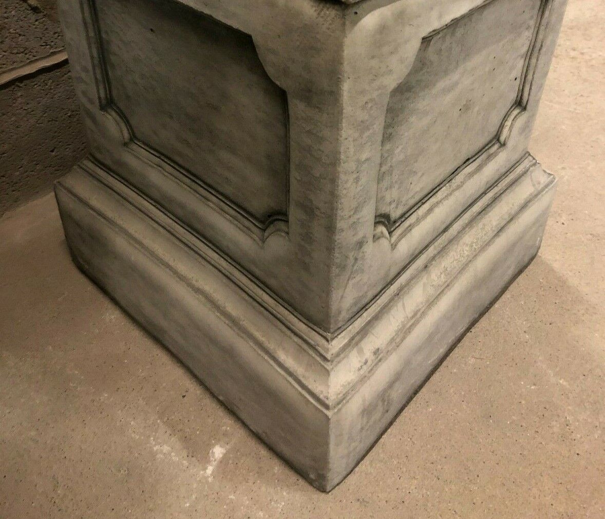 Close-up of square stone garden plinth base with detailed edging, offering a solid and stylish platform for outdoor decorative pieces.