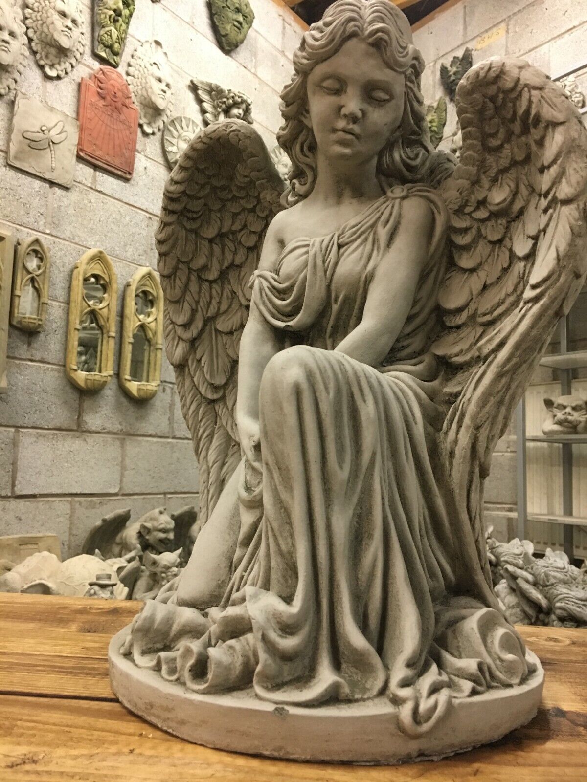 Close-up of Elegant Stone Angel Garden Pedestal Statue for Landscaping. Focus on the angel’s serene face and detailed drapery in stone finish.