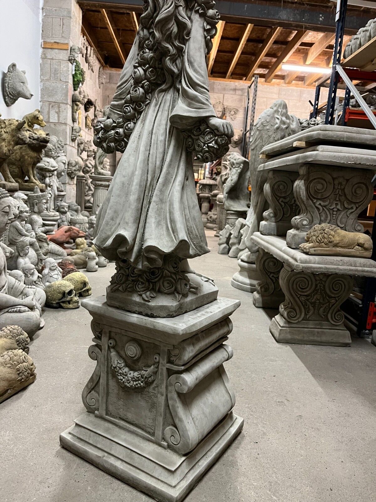 Side angle of Stone Rose Lady Garden Statue on plinth, featuring flowing gown and intricate stonework for outdoor decor.