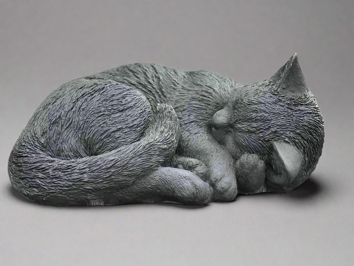 Elegant stone sculpture of a curled sleeping cat, perfect for outdoor garden art or as a heartfelt memorial ornament.