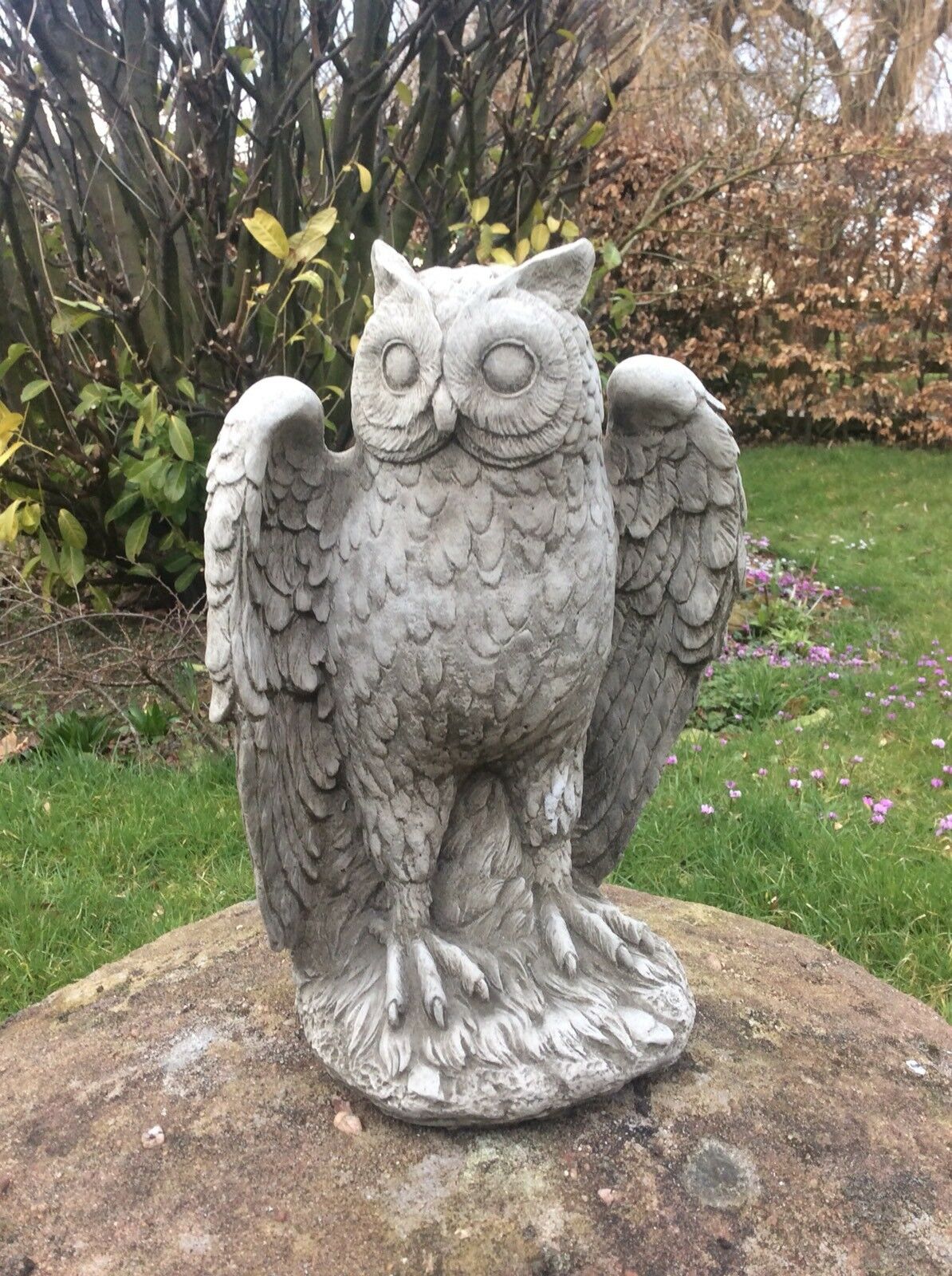 Handcrafted Stone Owl Garden Statue - Antique Weatherproof Finish with raised wings, set in a landscaped garden for decorative charm.