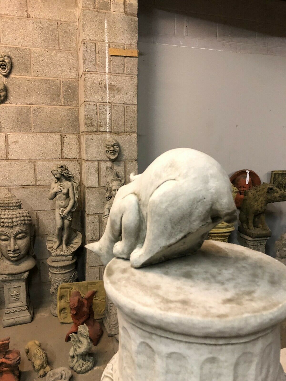 Rear view of limestone Garden Cat Statue in crouched pose, designed for outdoor display in flowerbeds or patios.