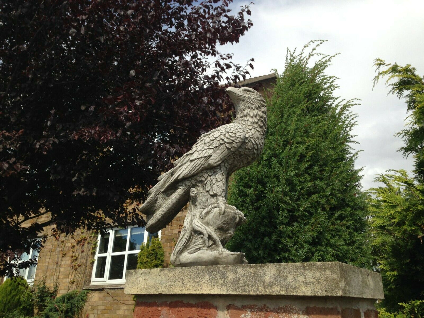 Garden Eagle Statue – Stone Perched Decor on brick base, featuring lifelike carving and weatherproof design for home and garden use.