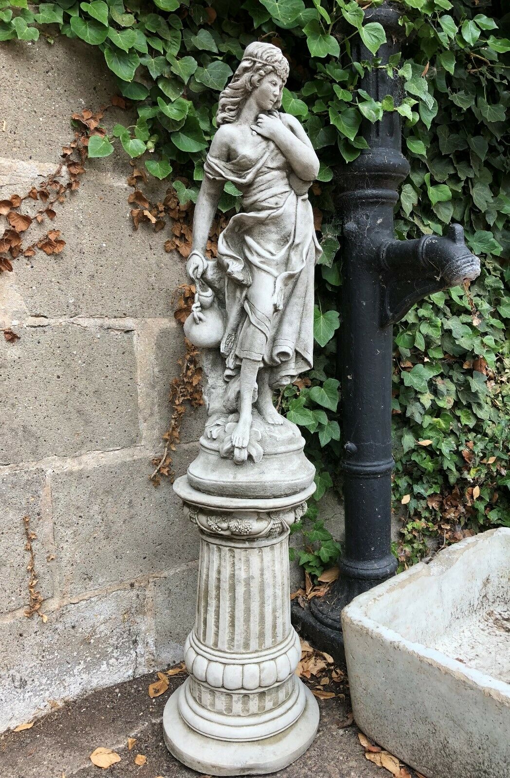 Full view of Garden Stone Statue - Jug Lady Plinth on fluted pedestal, ideal for lawn or balcony decoration in classic garden themes.