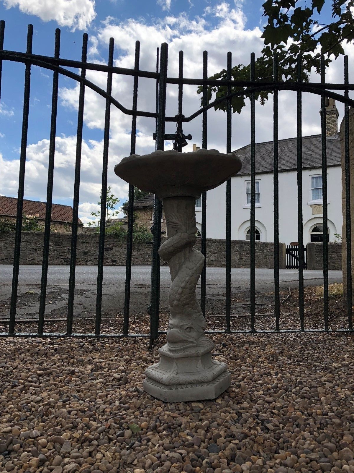 Outdoor Stone Serpent Bird Bath standing tall with intricate serpent statue, blending sculpture and function for elegant garden decoration.