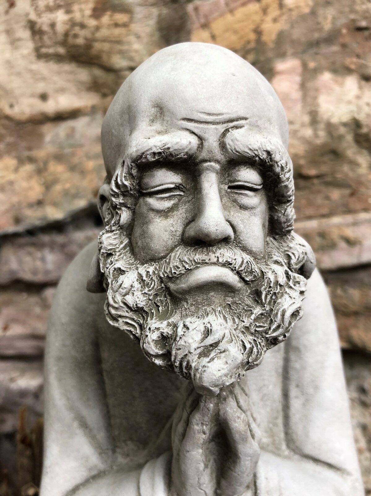 Extreme close-up of the Stunning Stone Praying Old Monk Sculpture Garden Ornament showing fine stone detailing and lifelike features.
