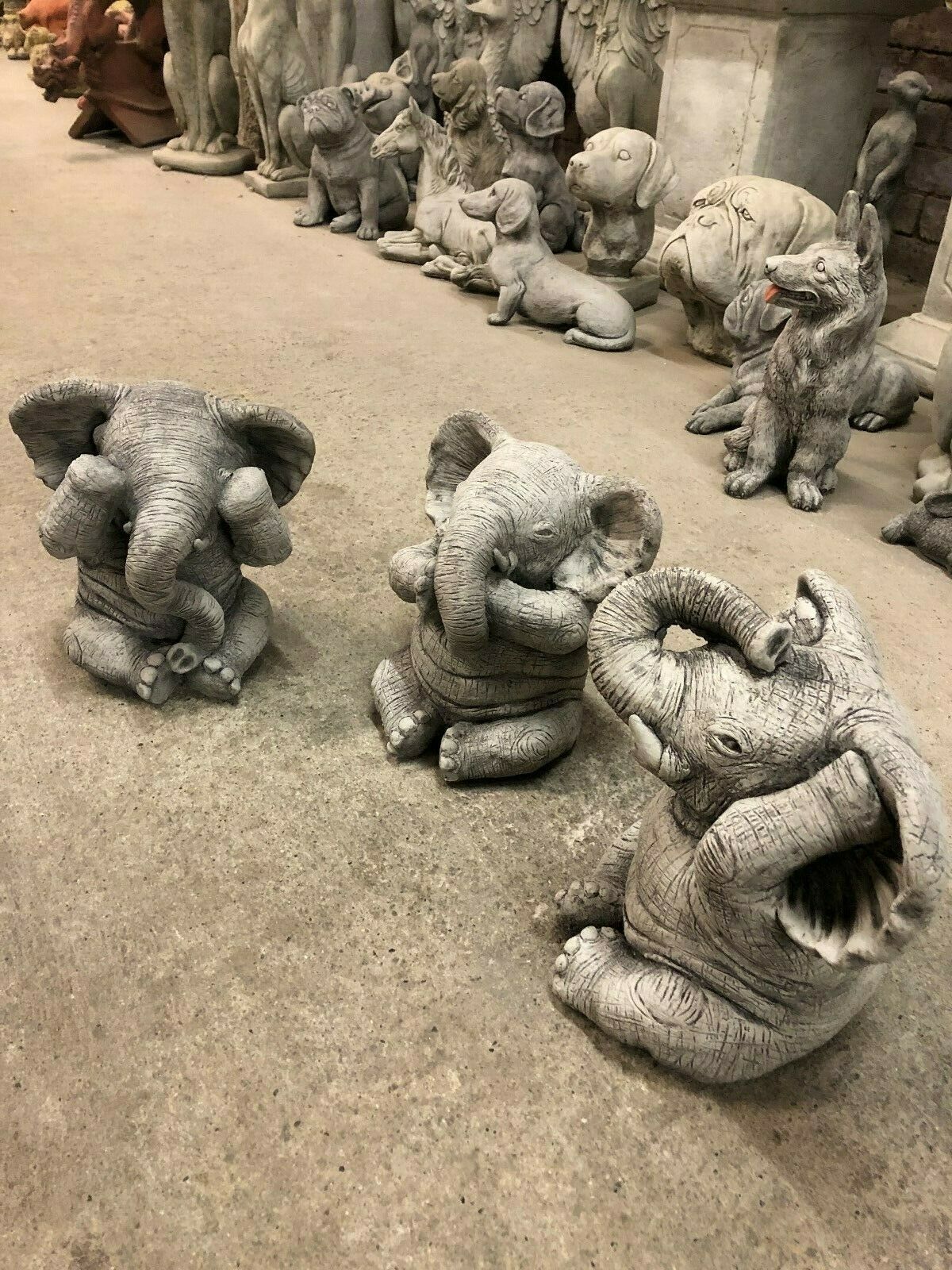 Side view of three stone Elephant Ornaments in 'No Evil' poses, ideal for patios, flowerbeds, or indoor decorative accents.