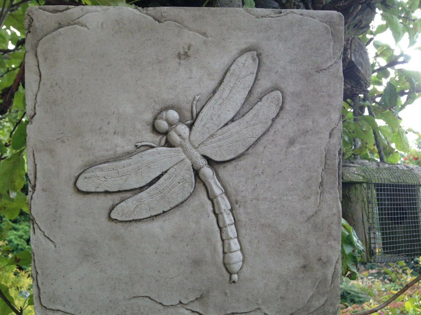Close-up of Dragonfly Garden Wall Plaque - Stone Garden Decor. Features intricate dragonfly carving on weather-resistant square stone tile.