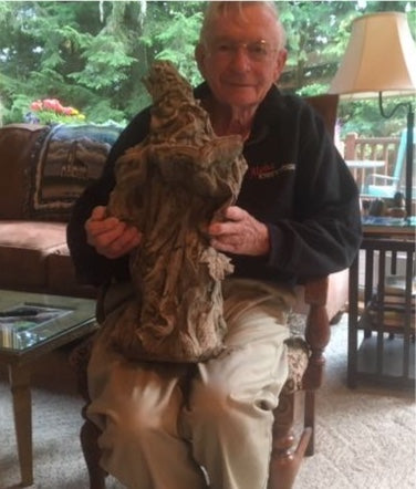 Man holding Wizard Garden Statue indoors, showing scale and craftsmanship of this enchanting garden decor piece.