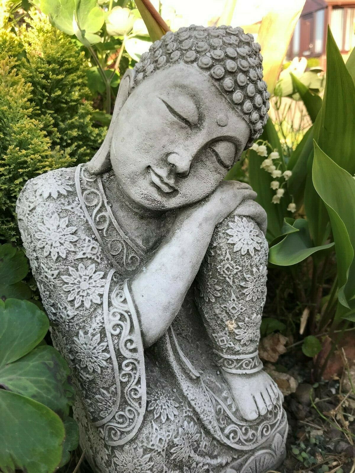 Close-up of serene Stone Sleeping Buddha Statue with floral robe detail, ideal for creating a calming garden atmosphere with zen aesthetics.