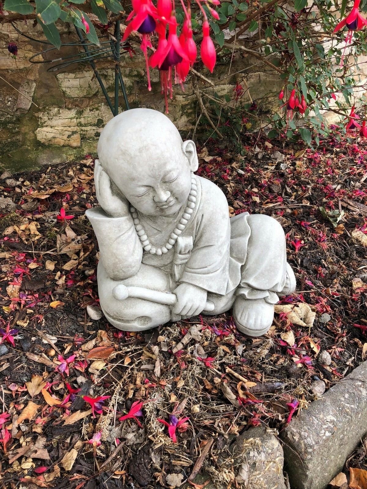 Outdoor Stone Resting Monk Sculpture Garden Ornament with peaceful expression, designed for weather resistance and spiritual garden ambiance.