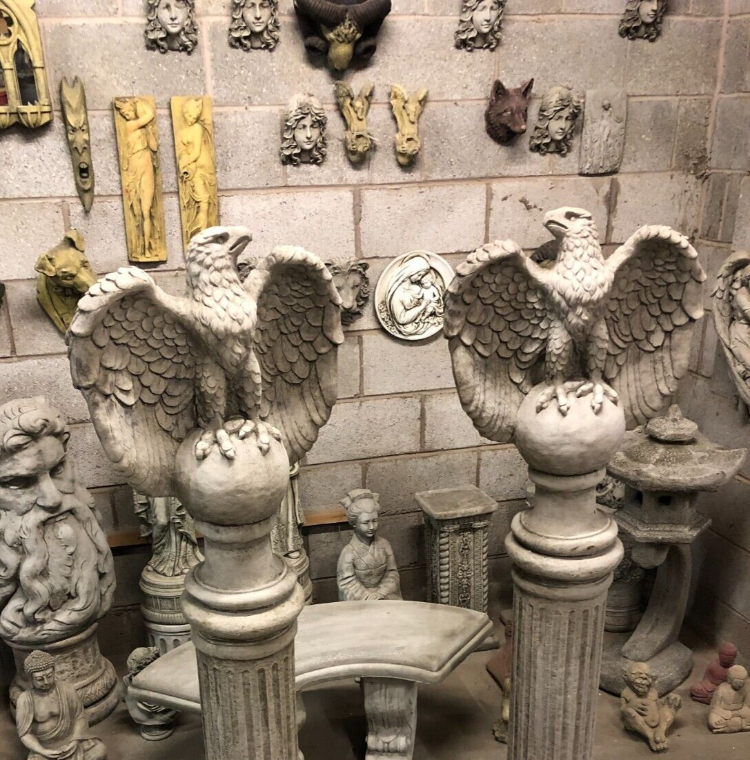 Close-up of eagle garden statues with wings spread, mounted on round stone bases atop fluted columns, great for lawn ornamentation.