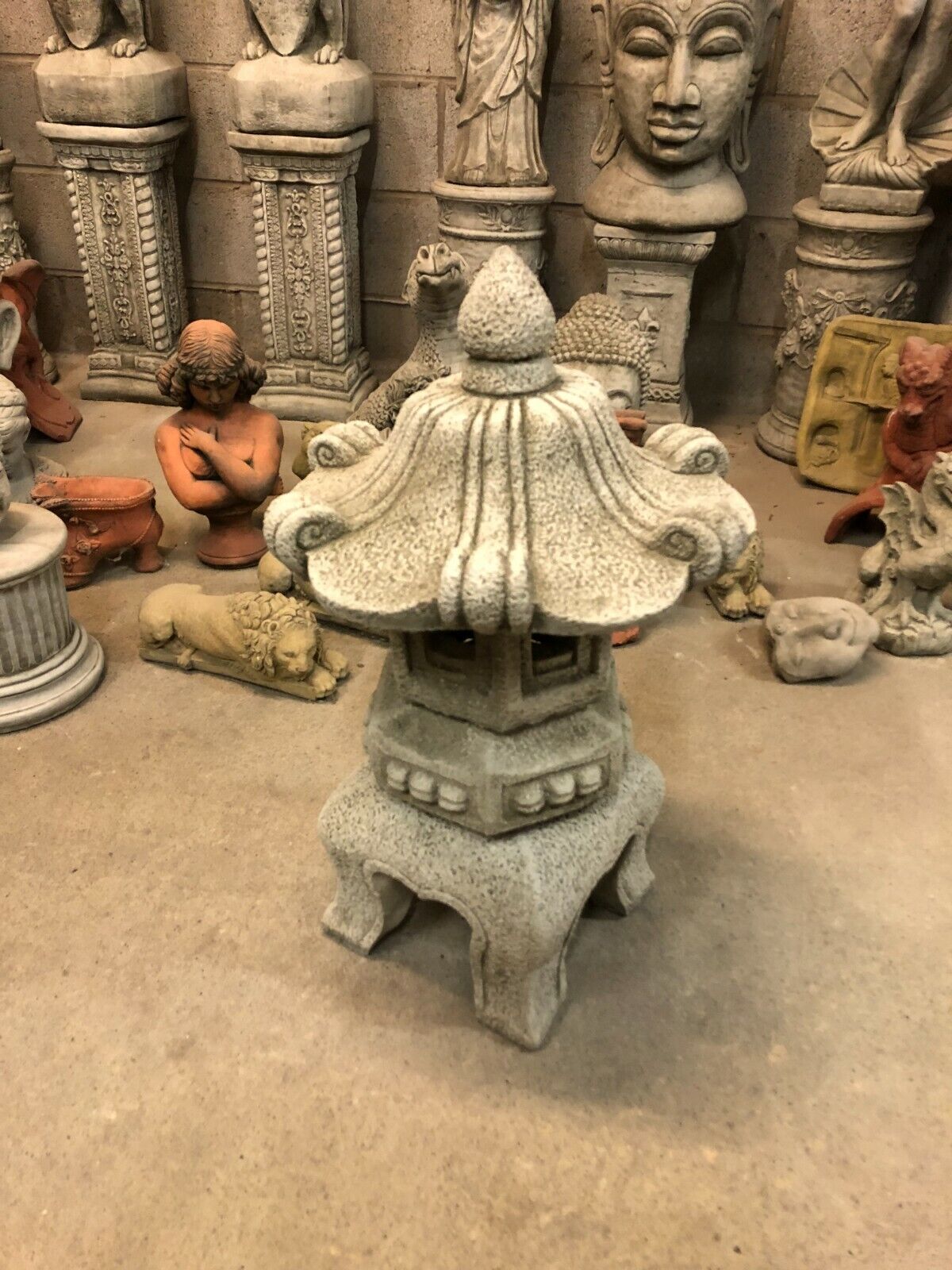 Decorative Stone Pagoda Lantern with curved roof and antique texture, perfect for enhancing Asian-inspired garden aesthetics.