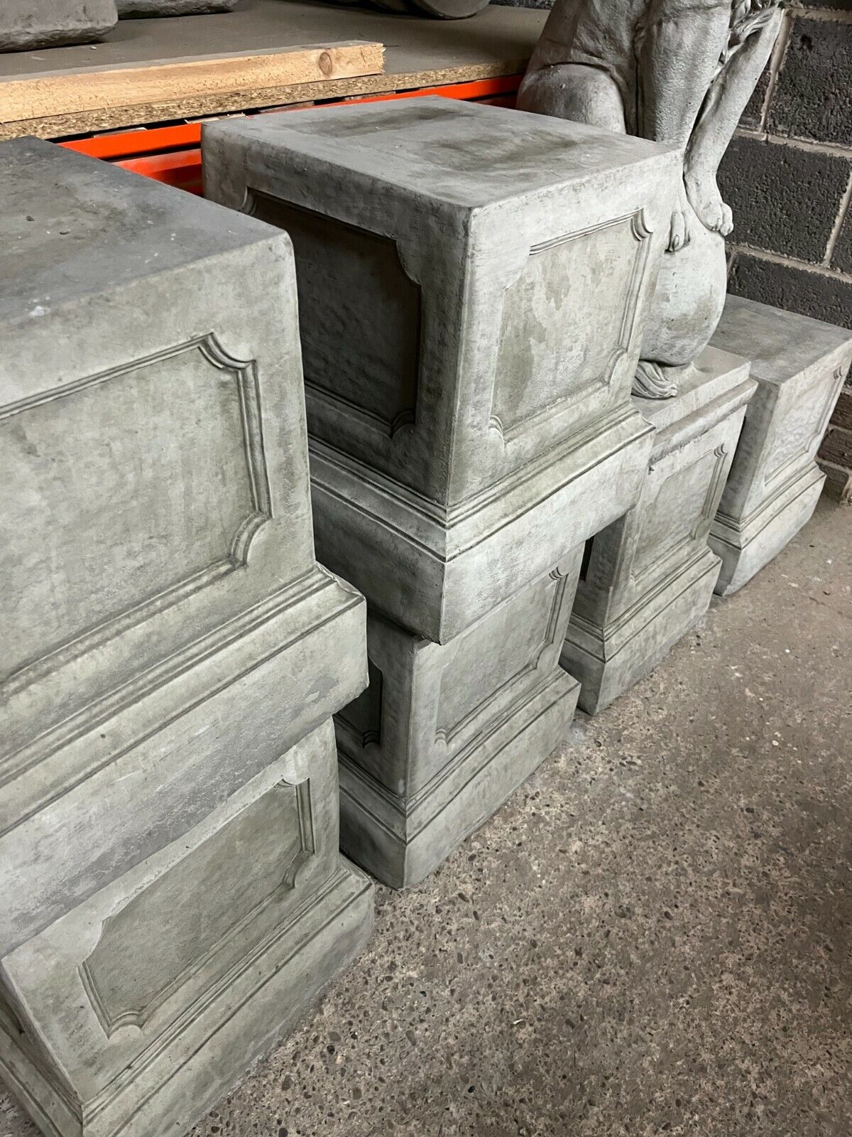 Stacked classic stone garden plinths in grey concrete finish, showcasing durable construction for stable outdoor decor support.