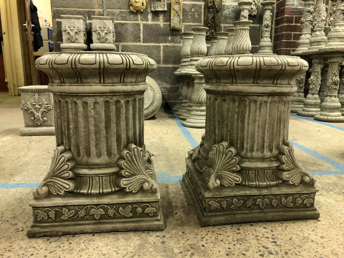 Pair of Stone Garden Plinths in classical design with fluted columns and ornate leaf detailing, ideal for outdoor sculpture bases or garden decor.
