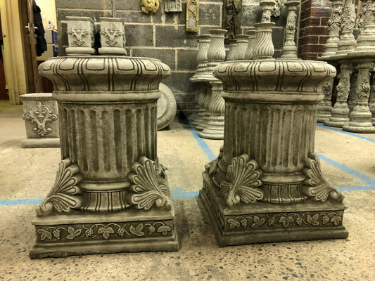Pair of Stone Garden Plinths in classical design with fluted columns and ornate leaf detailing, ideal for outdoor sculpture bases or garden decor.