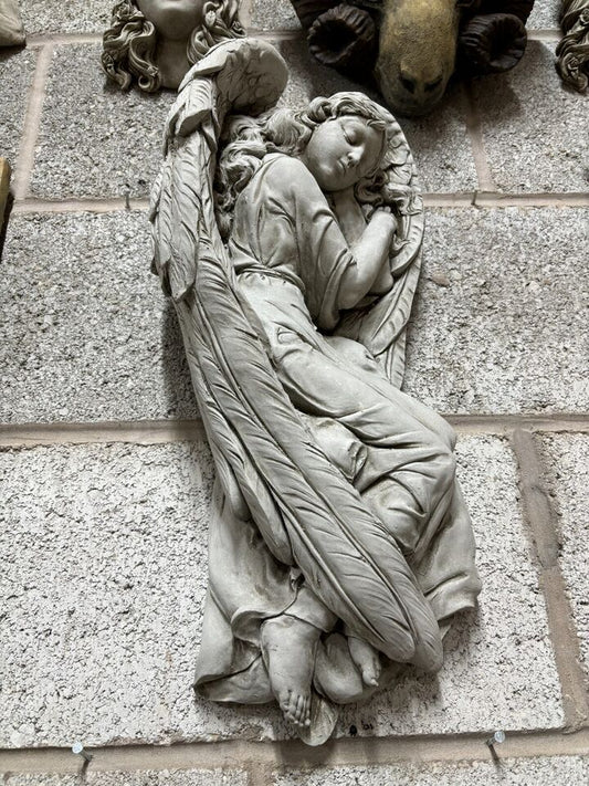 Winged Angel Garden Plaque in antique finish mounted on a stone wall, showcasing detailed craftsmanship and weatherproof limestone design.