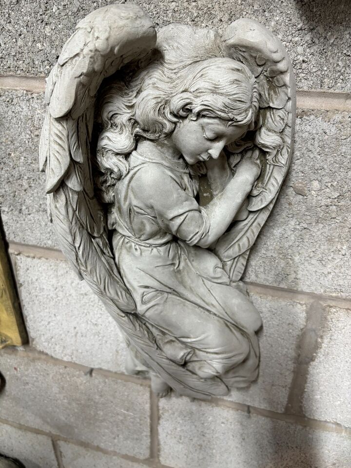 Close-up of the angel's serene face and folded hands on the Winged Angel Garden Plaque, crafted from durable limestone.