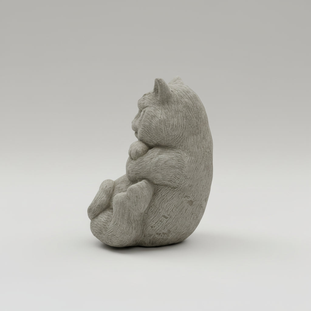 Gray stone sculpture of a cat on a white background