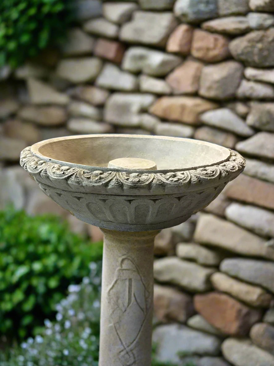 Elegant Bird Bath Top Replacement in classic style with carved detailing, mounted on a decorative pedestal near a stone wall.