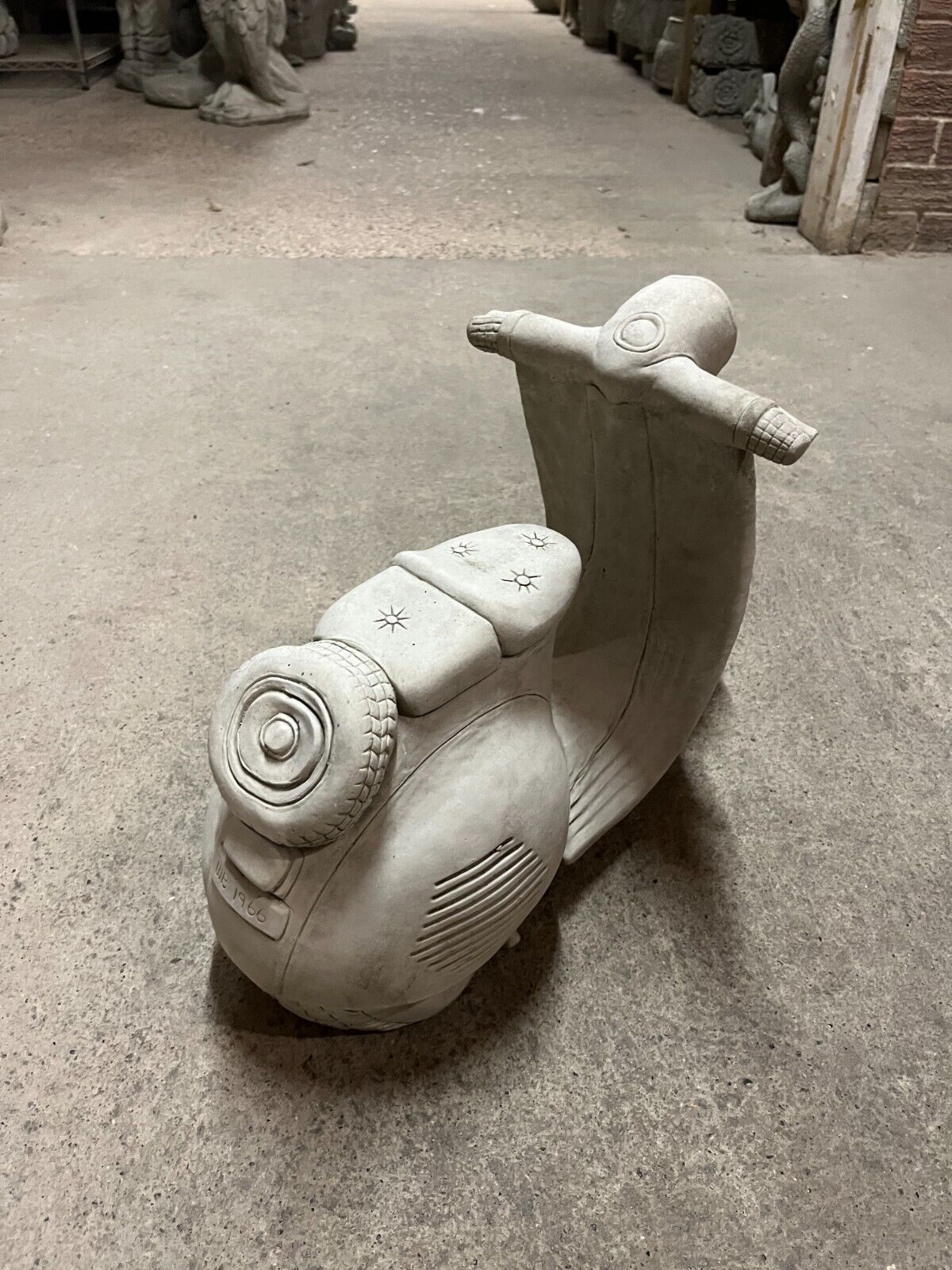 Rear angle of Vesper Motorbike Garden Ornament showcasing spare tire and sculpted body, perfect for lawn or patio decoration.