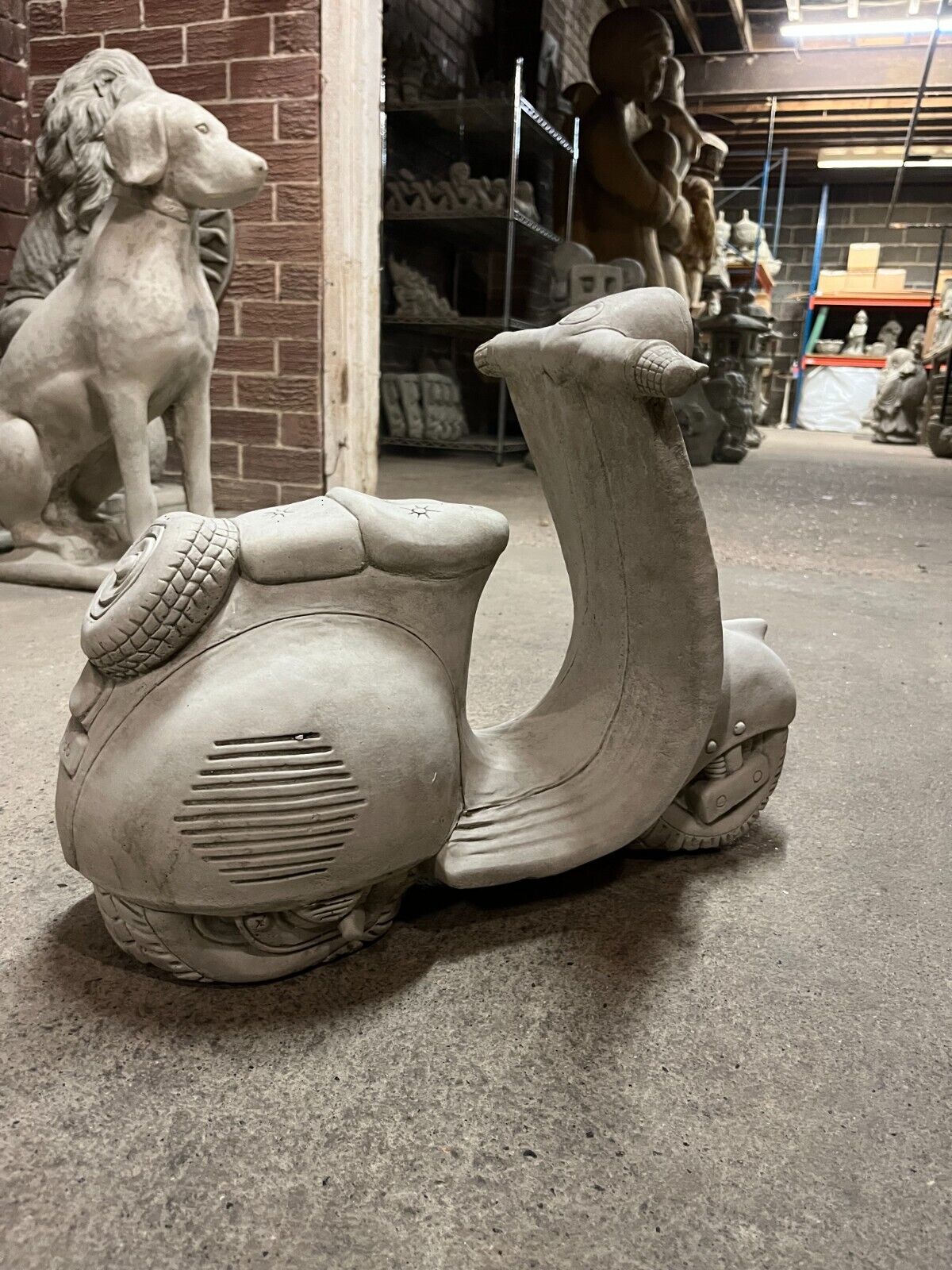 Back-side view of Vesper Motorbike Garden Ornament in antique grey stone finish, emphasizing realistic wheel and engine detailing.