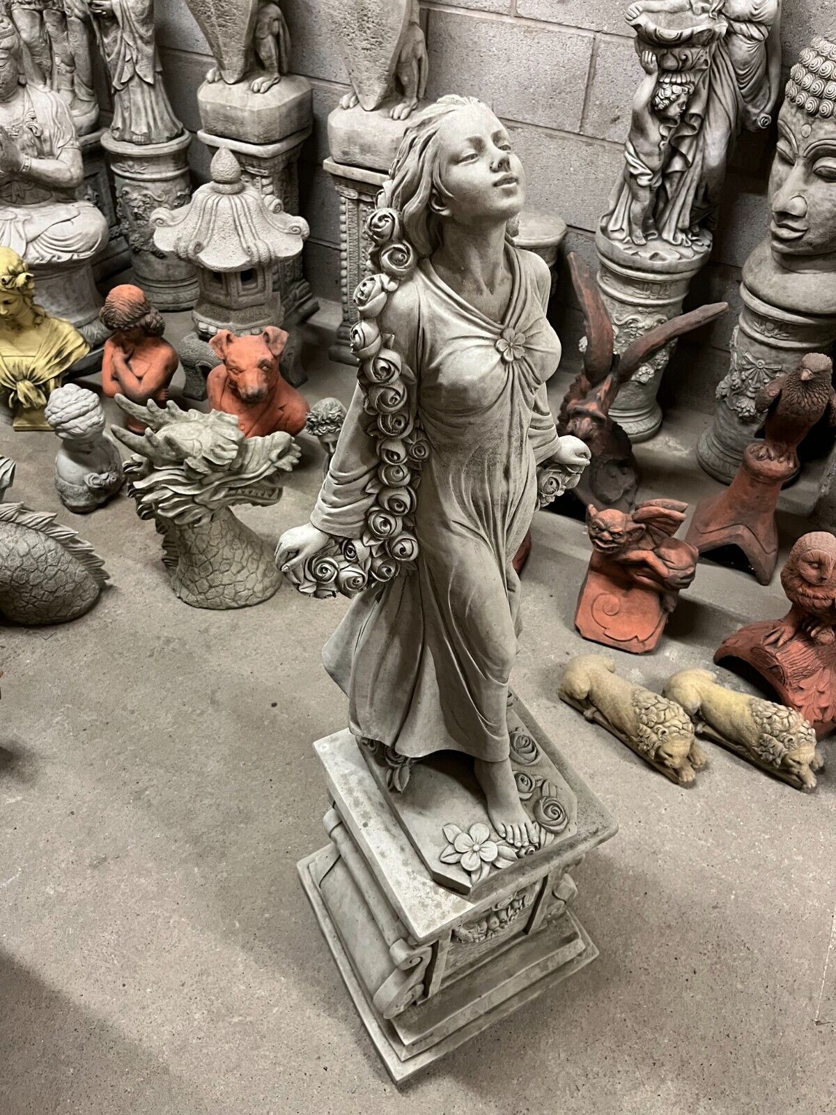 Elegant Garden Lady Statue on pedestal with detailed stone roses and flowing gown, perfect for lawn ornaments and garden sculptures.