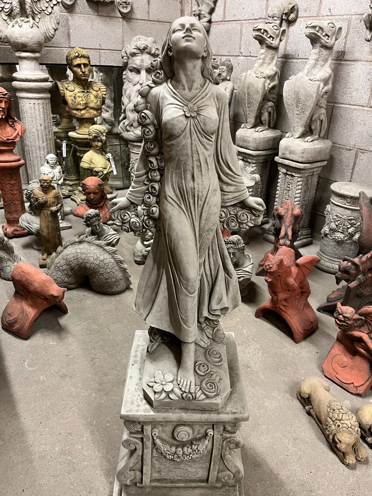 Stone Rose Lady Garden Statue with antique finish, featuring a barefoot woman holding cascading roses, ideal for outdoor garden decor.