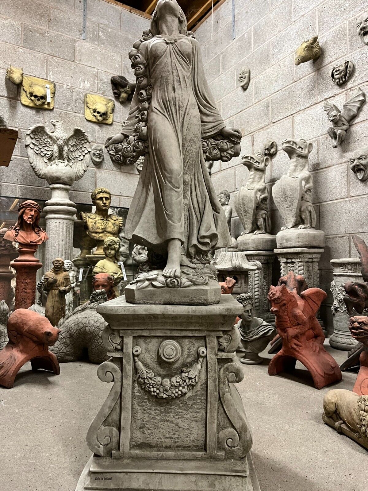 Full back view of Stone Rose Lady Garden Statue on ornate pedestal, showcasing detailed craftsmanship and floral garland relief.