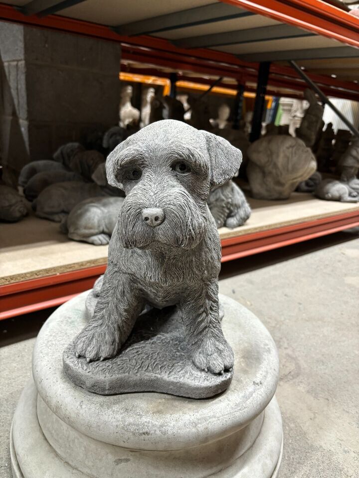 Stone Schnauzer garden statue with lifelike detail, seated on a round base, ideal for outdoor decor in home gardens or patios.
