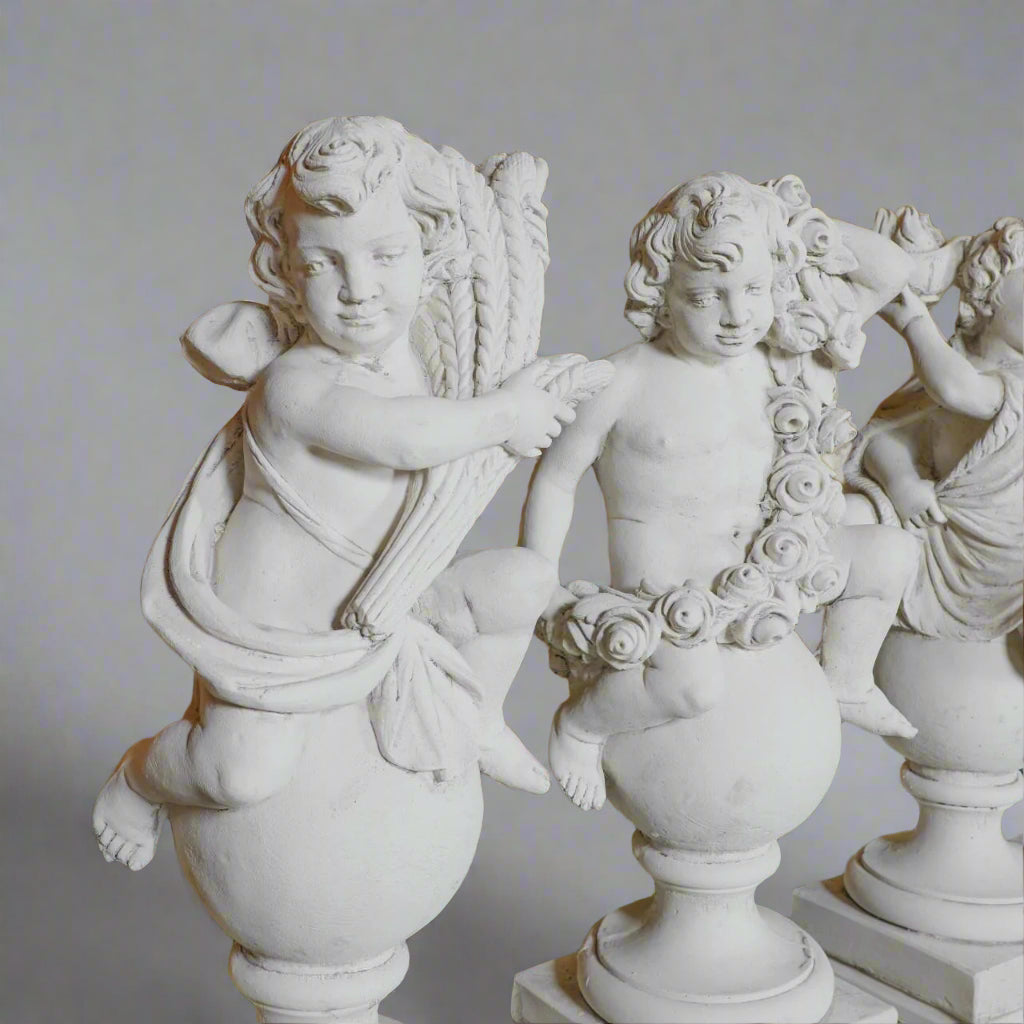Angled view of Spring and Summer cherubs from the Four Seasons Stone Statues, showcasing artisan craftsmanship and seasonal symbolism.
