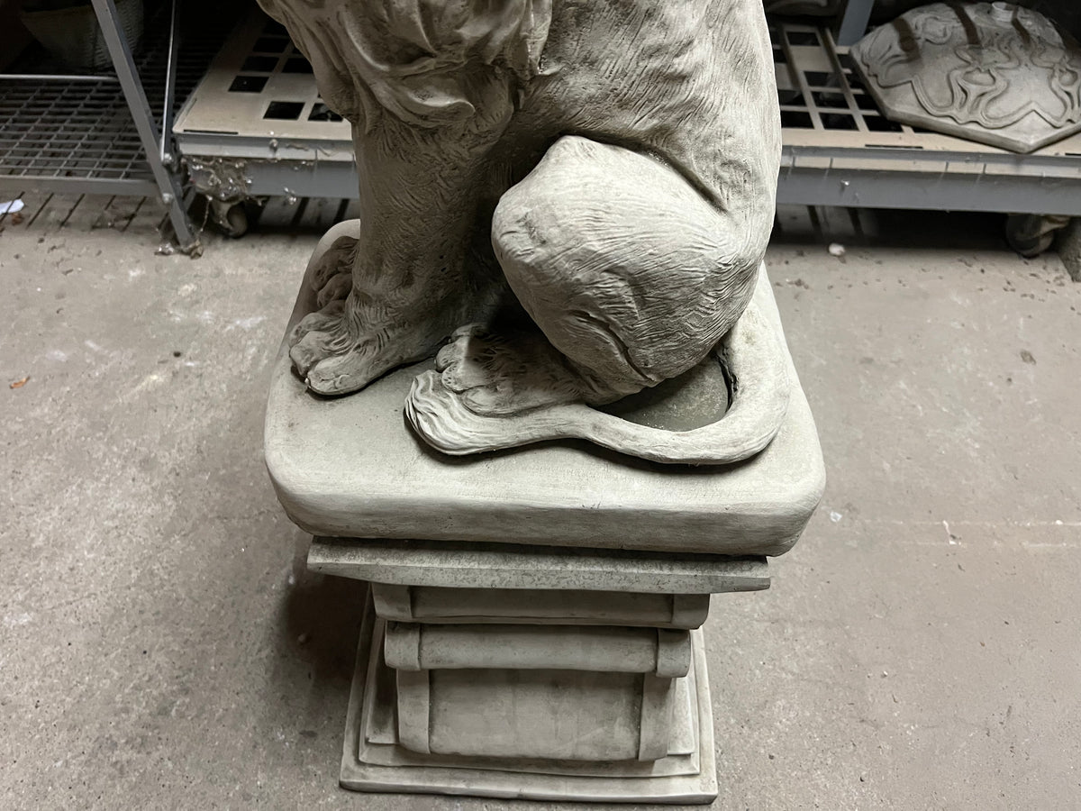 Close-up of lion statue's tail and plinth base, showcasing craftsmanship and durability for outdoor garden settings.