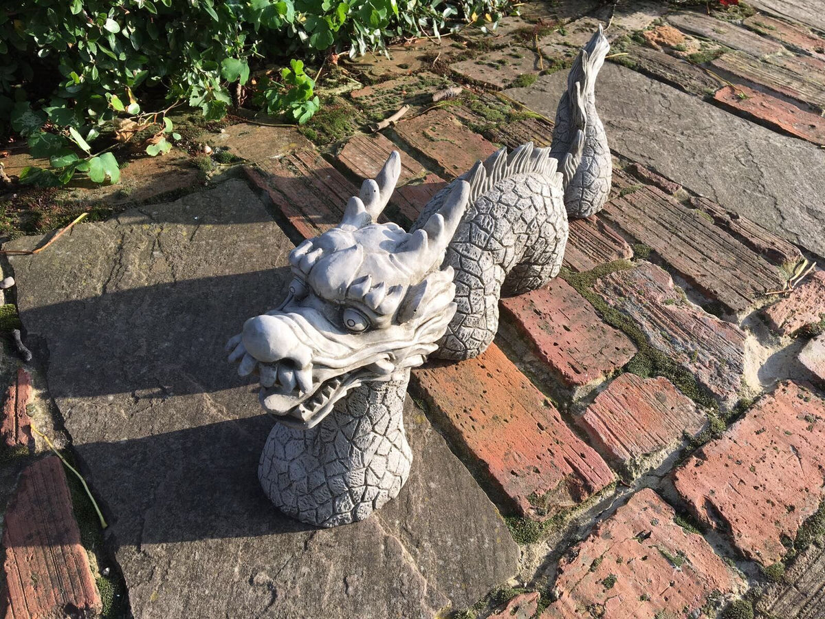 Chinese Dragon Stone Ornament - Antique Garden Decor with intricately carved head and body segments placed on outdoor stone tiles.
