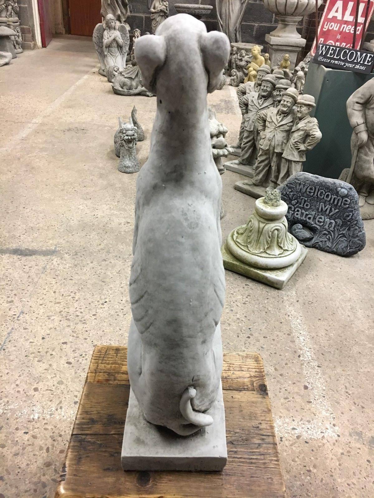 Rear view of a greyhound garden statue showing tail and back muscle detail, crafted from weatherproof limestone.