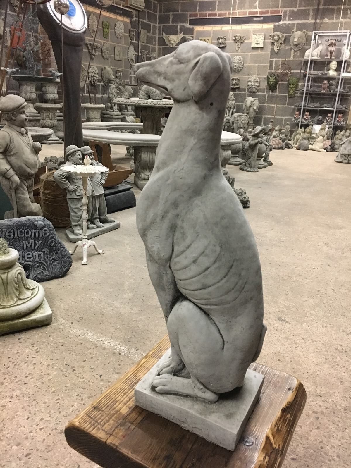 Side angle of a seated greyhound statue with realistic body contours, perfect for elegant lawn and garden decoration.