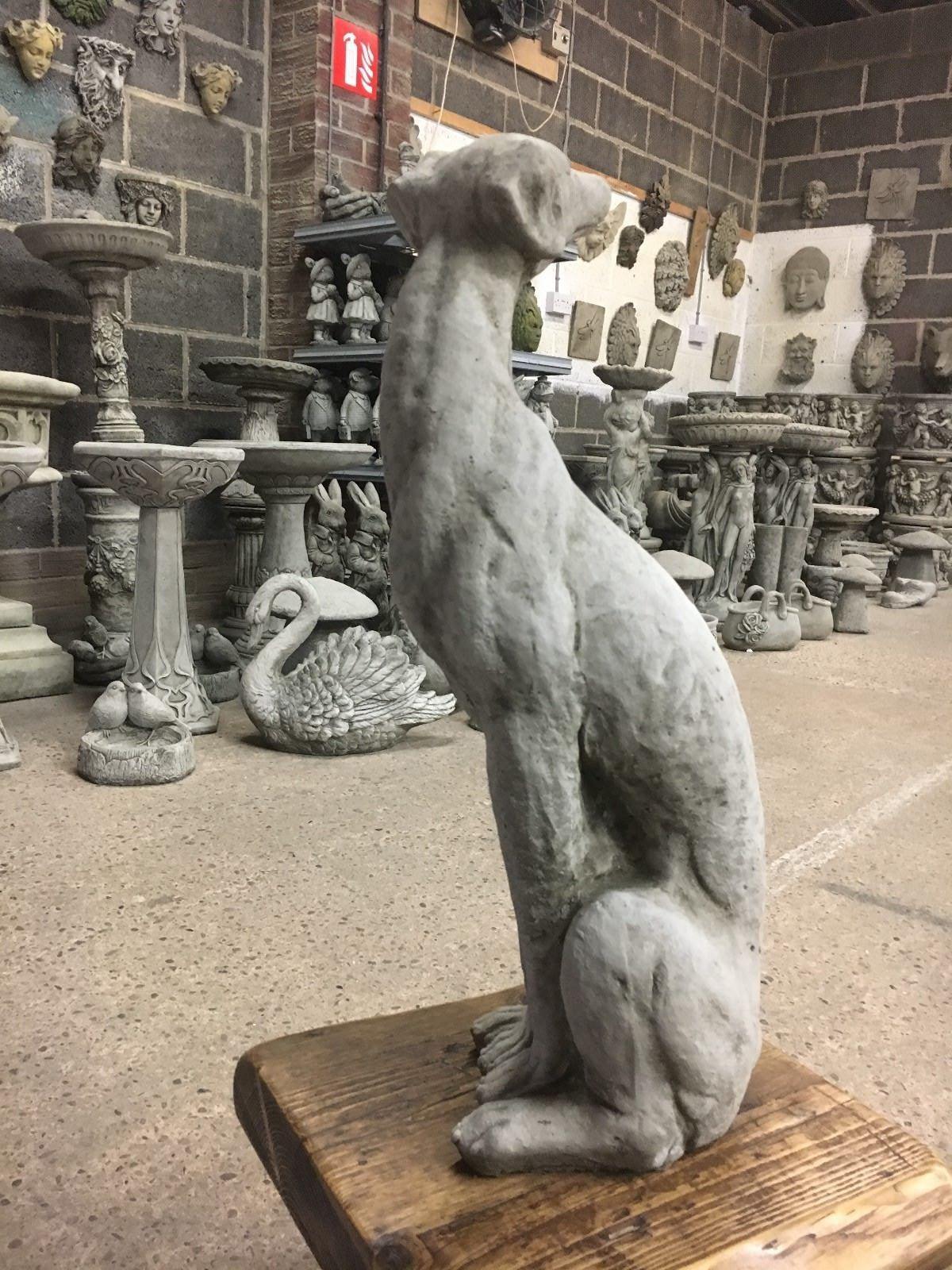 Profile view of a seated greyhound statue in limestone, showcasing elegant curves and weather-resistant craftsmanship.