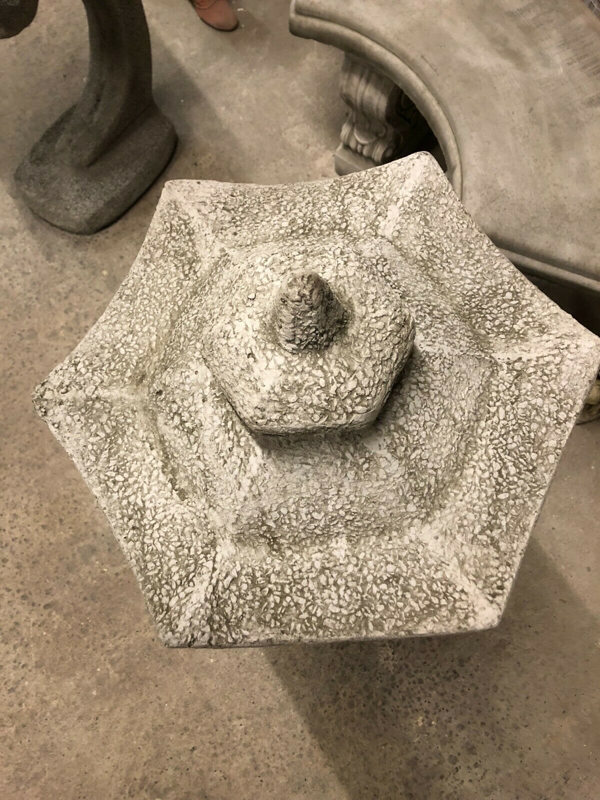 Top view of hexagonal roof design on stone pagoda lantern statue, showcasing intricate texture and antique grey detailing.