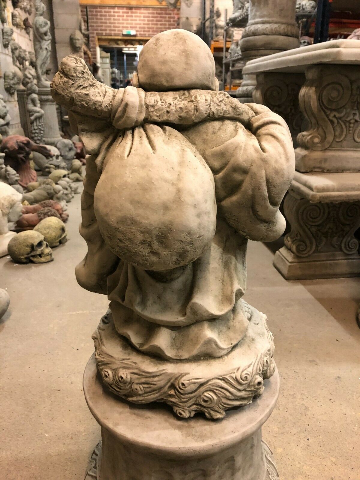 Rear view of Stone Laughing Buddha Garden Statue with Plinth, showing large sack and robe folds, crafted in durable limestone for outdoor use.