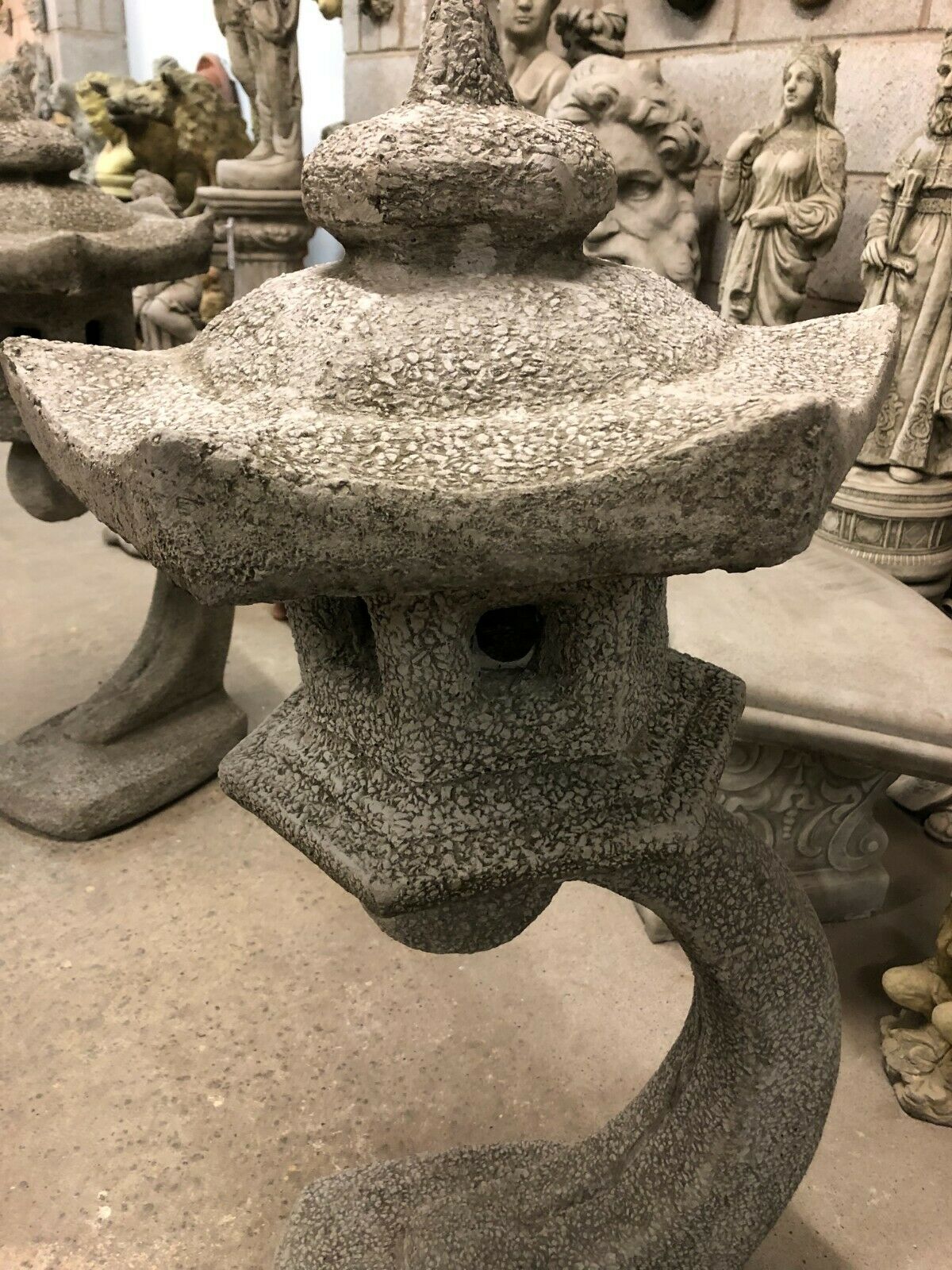 Detailed view of stone pagoda lantern with curved base and textured antique grey surface, ideal for outdoor garden décor.