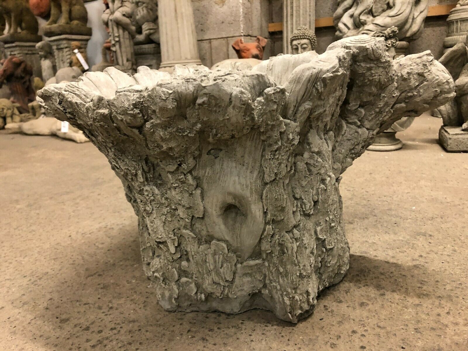Back view of stone tree stump bird bath showing naturalistic knot and bark detailing, crafted for outdoor garden decoration.