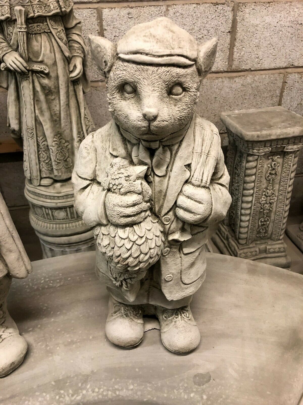 Front view of gamekeeper statue from Stone Gamekeeper & Poacher Statues-Garden Decor | Solid & Durable. Holding a pheasant, ideal for rustic garden themes.