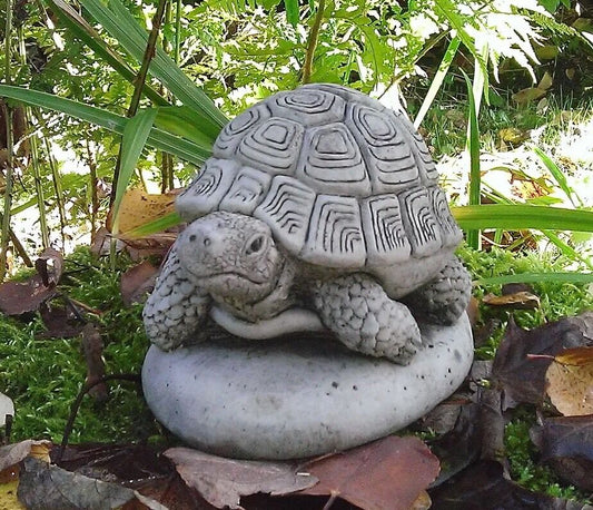 Stone Tortoise Garden Ornament with antique grey finish resting on a stone base, ideal for enhancing outdoor garden aesthetics year-round.