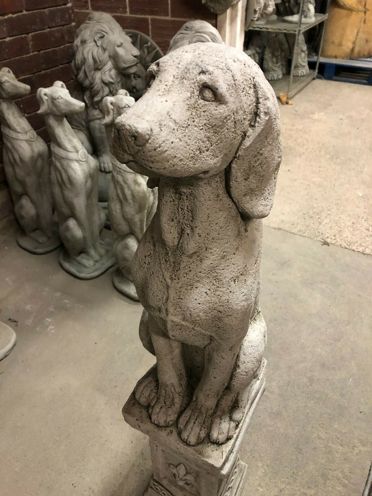 Close-up of a handcrafted stone hound statue with textured antique grey finish, showcasing lifelike detail and weather-resistant design.