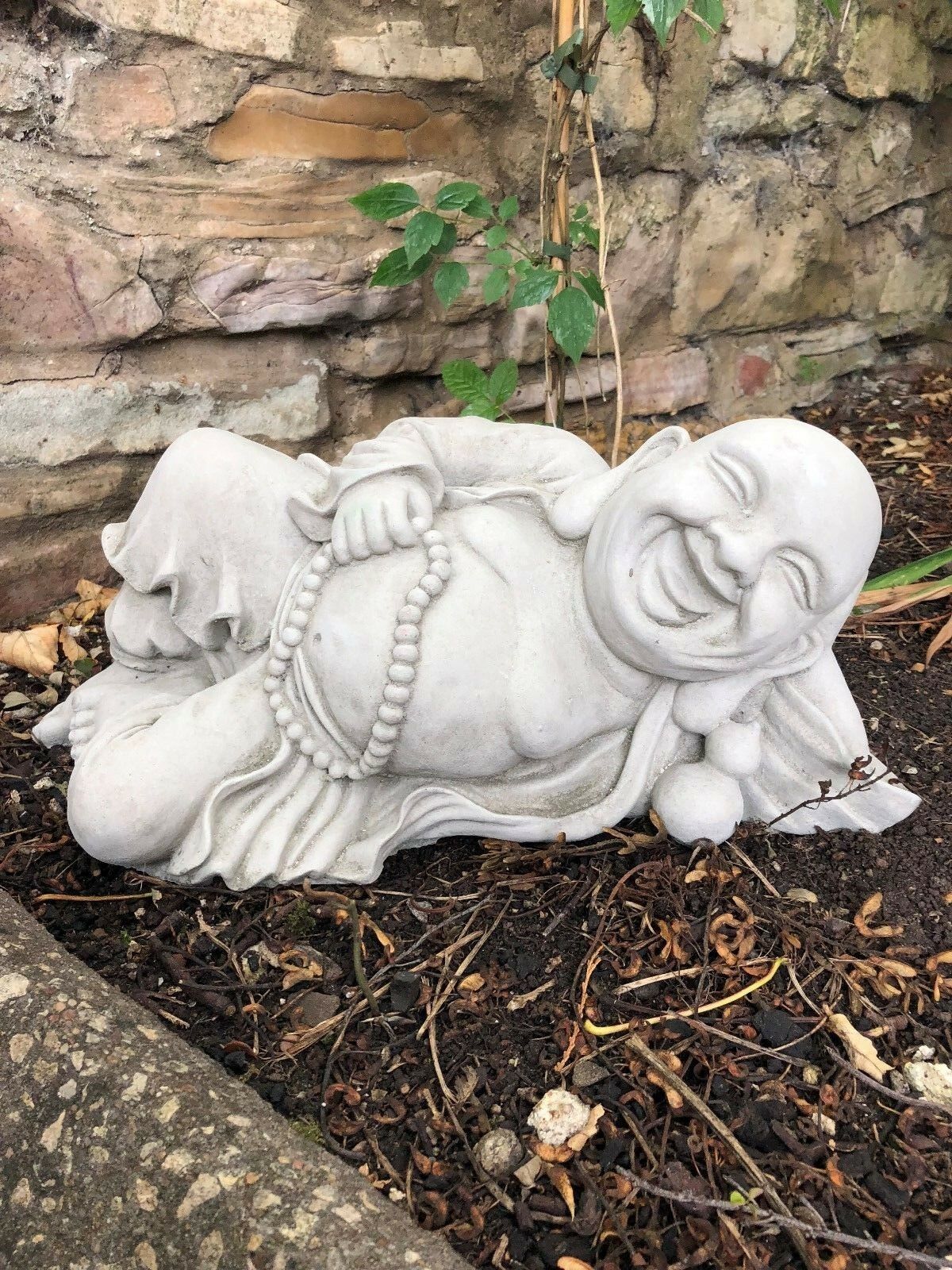 Decorative Jolly Stone Buddha statue in relaxed pose, crafted for outdoor use with antique stone finish for garden serenity.