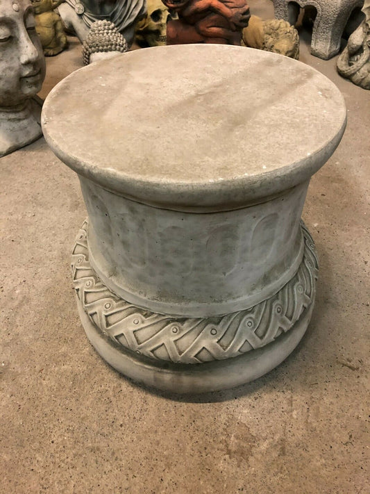 Solid stone garden plinth with antique finish, featuring a round top and detailed carved base, ideal for outdoor decorative display.