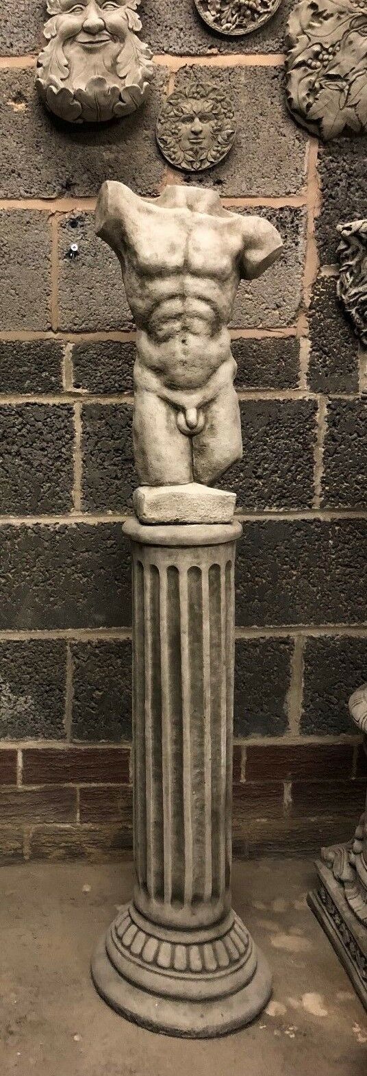 Full view of male torso statue on fluted limestone plinth. Classic Grecian design for weather-resistant garden decoration.