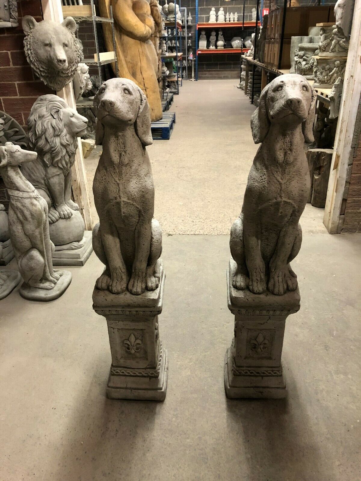 Pair of Stone Hound Garden Statues with antique grey finish on decorative plinths, ideal for outdoor decor in home gardens or patios.