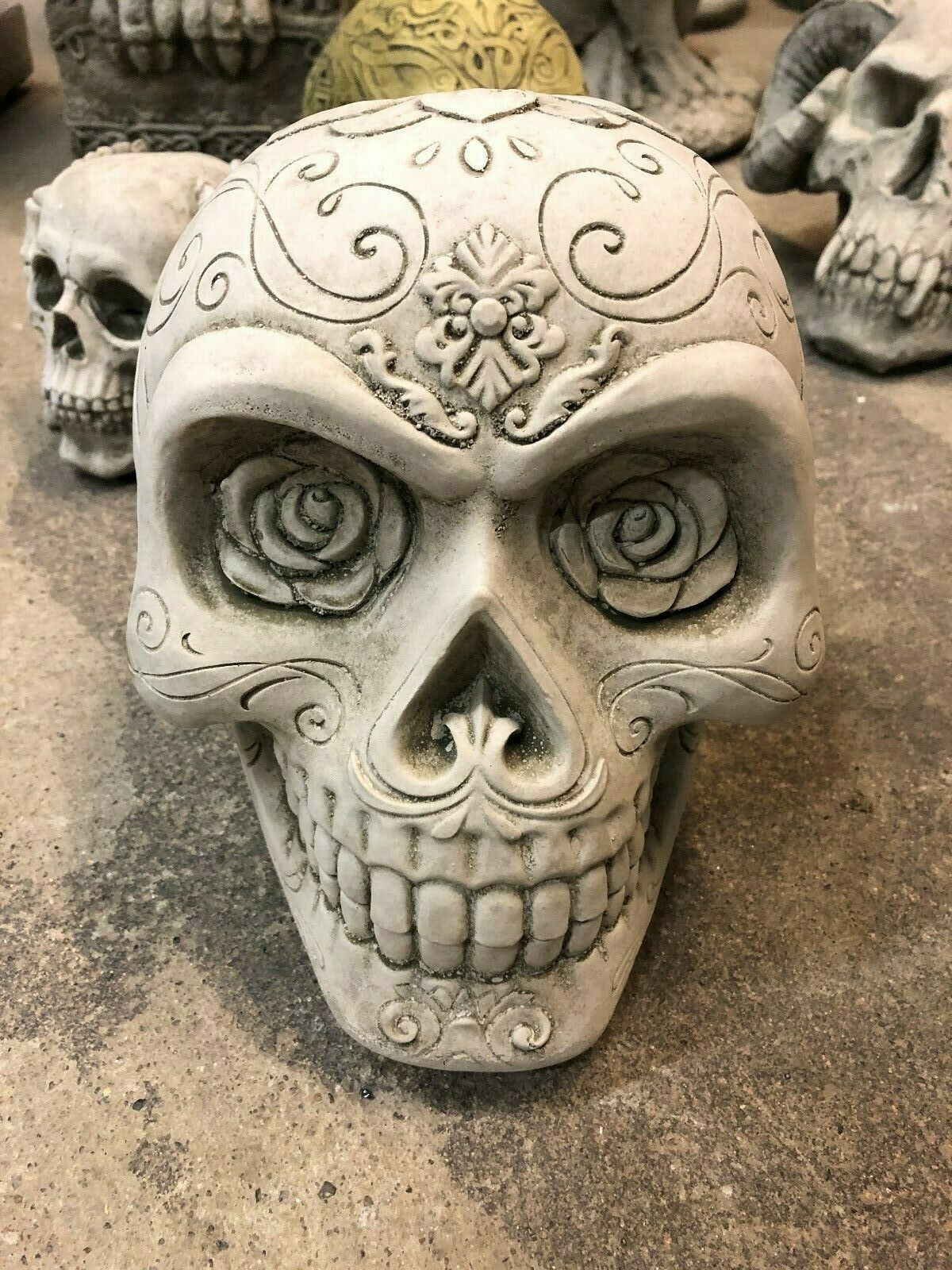 Stone Skull Garden Ornament with antique rose detailing and floral carvings. Crack-resistant limestone sculpture ideal for outdoor garden decor.