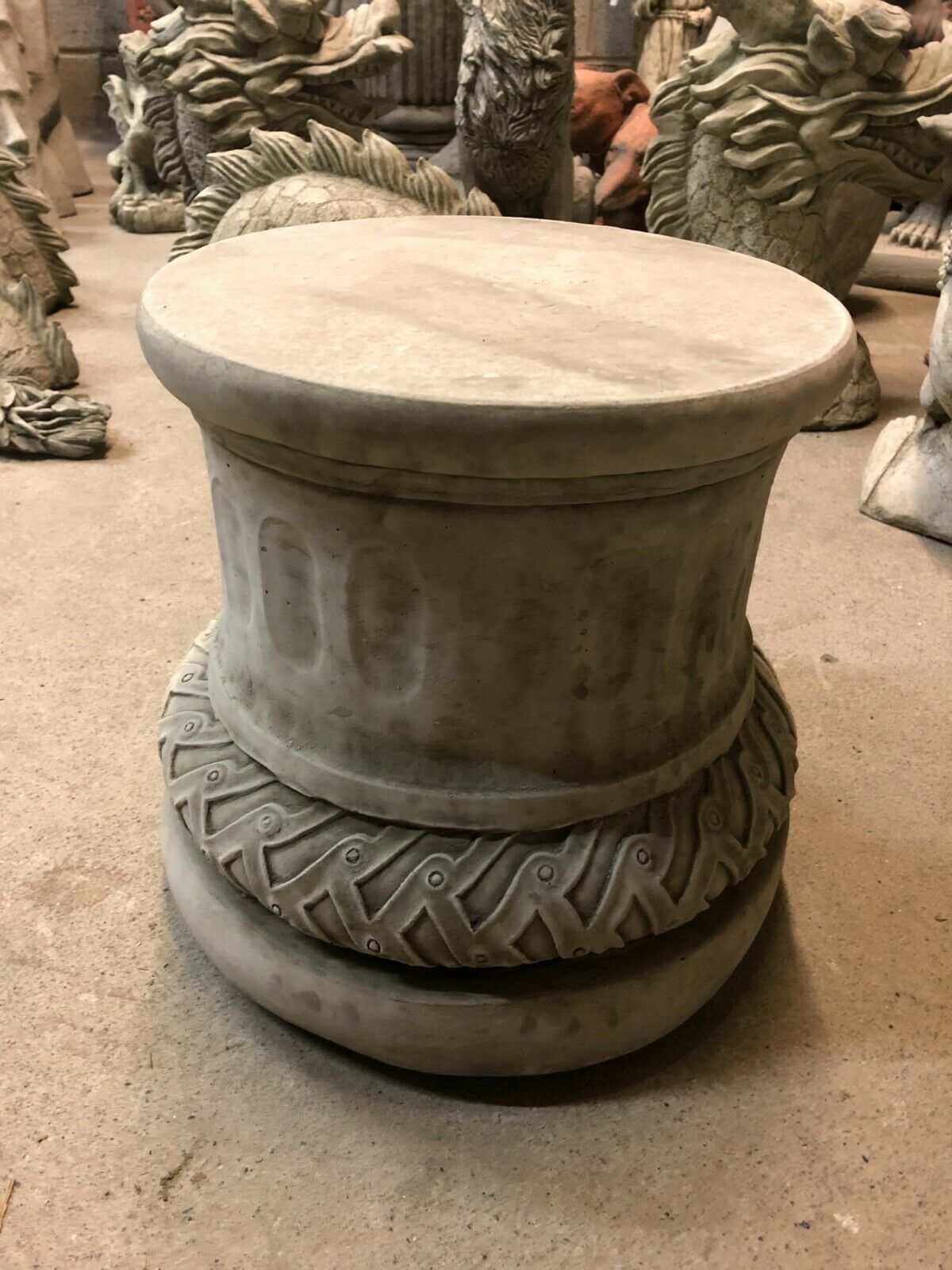 Sturdy limestone garden plinth with intricate base design, perfect for showcasing statues or planters in patios or garden spaces.