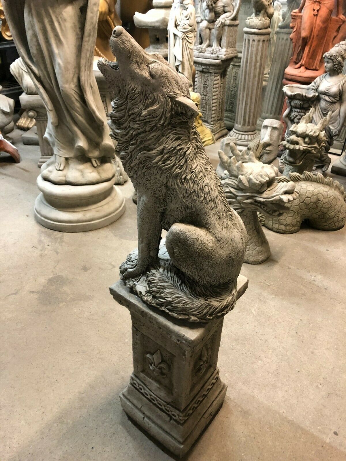 Detailed Howling Wolf Garden Statue on square stone pedestal, perfect for enhancing garden landscapes with durable, weather-resistant design.